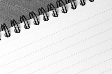 Spiral bound reporters notepad closeup on a desk in black and white