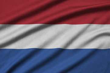 Netherlands flag  is depicted on a sports cloth fabric with many folds. Sport team banner
