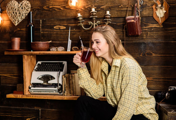 Girl in casual outfit sits in wooden vintage interior. Lady on dreamy face in plaid clothes looks...