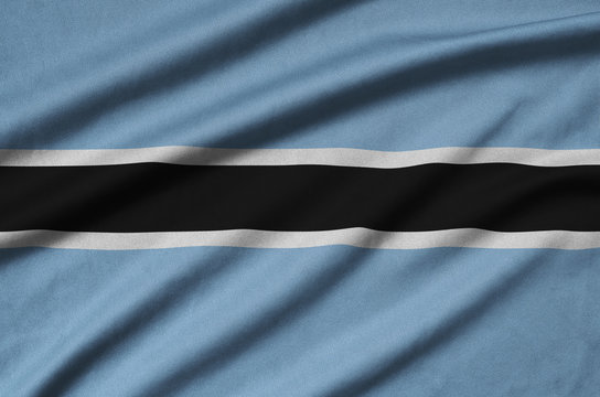 Botswana flag is depicted on a sports cloth fabric with many folds. Sport team banner