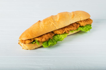 Fresh submarine sandwich with ham, cheese, tomatoes, cucumbers, lettuce and onions isolated on white background