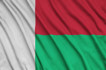 Madagascar flag  is depicted on a sports cloth fabric with many folds. Sport team banner