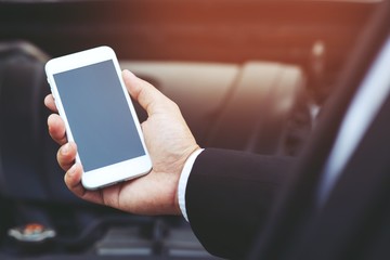 close up businessman hand using a mobile smart phone call a car mechanic ask for help assistance because car broken.