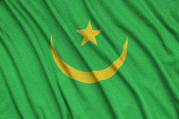 Mauritania flag  is depicted on a sports cloth fabric with many folds. Sport team banner