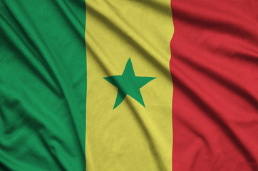 Senegal flag  is depicted on a sports cloth fabric with many folds. Sport team banner