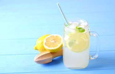 Ice cold lavander lemonade, lemon, straw, mint. Classic virgin mojito cocktail, non alcoholic drink with ice, vintage mason jar glass blue wood texture table background. Copy space, top view close up.