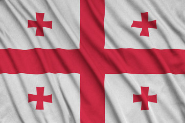 Georgia flag  is depicted on a sports cloth fabric with many folds. Sport team banner