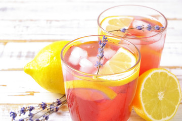 Red berry lavander lemonade, lemon, straw. Virgin strawberry mojito, non alcoholic cocktail with ice in vintage drinking glass, Isolated on pale grunged wood background. Copy space, top view close up