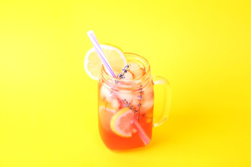 Red berry lavander lemonade, lemon and straw. Virgin strawberry mojito, non alcoholic cocktail with ice in vintage mason jar glass, Isolated on bright yellow background. Copy space, top view, close up