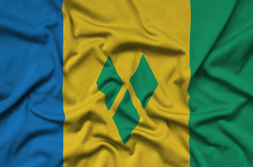 Saint Vincent and the Grenadines flag  is depicted on a sports cloth fabric with many folds. Sport...