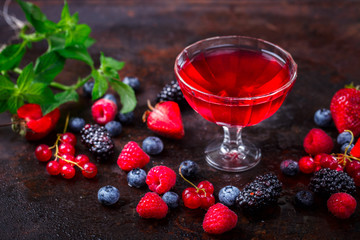 Drink from Berries in a glass cup, Decorated with Green Mint. Old dark Background. Superfoods and healthy lifestyle or detox diet food concept.