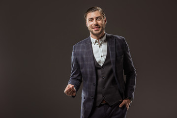 handsome stylish young man smiling at camera isolated on black