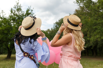 back of two womans in hats looking forward