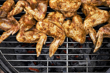 Spicy cooking chicken wings grilling on a summer barbecue