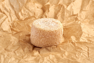 Crottin cheese on brown package paper.