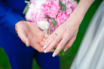 Close-up Bride and groom's hands with wedding rings. Groom putting golden ring on finger. Love and...