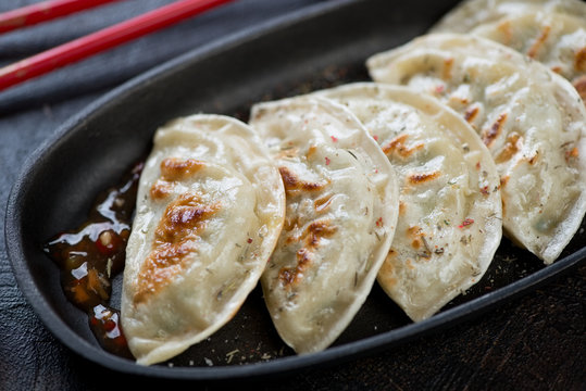 Closeup of potstickers or fried korean dumplings, selective focus, studio shot