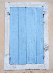 very old blue painted shutters on window in medieval french house in the provence