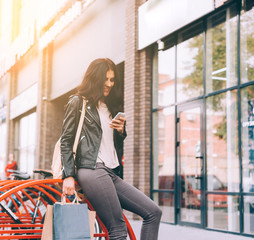 Young pretty latin woman walking near shops in city centre