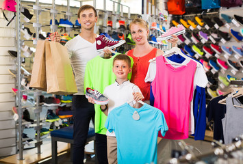 Fototapeta premium Positive parents with boy in sport store