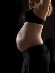 Baby belly in front of black background