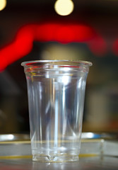 Empty plastic cup for milkshake on a background of bright glare.