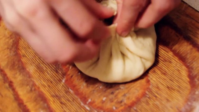 Raw Vak belyash - bashkir national homemade meat pies on wood chopping board at home kitchen. Preparing process,from different angles.