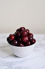 white bowl with sweet cherries