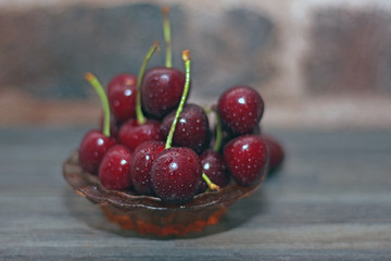 berries of sweet cherry with drops of water on a silver platter for breakfast