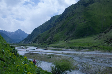 Georgian green velvet mountains with river and one girl in sunny day