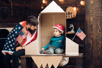 Family and childhood. Happy independence day of the usa. Patriotism and freedom. Travel and adventure. Father and small boy in paper rocket with American flag. Dream about career of cosmonaut