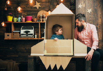 Rocket launch concept. Kid happy sit in hand made rocket. Child cute boy play cosmonaut or astronaut. happy family play with rocket made out of cardboard box
