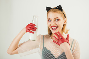 woman in red latex gloves catsuit licking milk like cat, over white background.