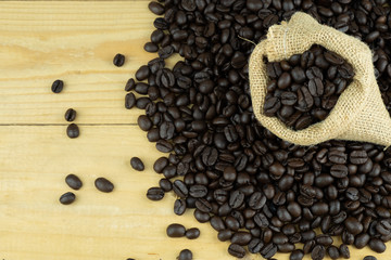 Coffee bean in sack on wooden table, close up copy space for presentation and template