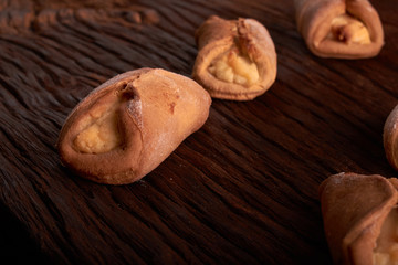 Baking cheesecakes with cottage cheese. blush baking on wooden table. sweet and tasty cookies on black background