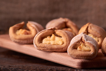 Baking cheesecakes with cottage cheese. blush baking on wooden table. sweet and tasty cookies on black background