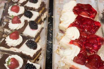 Tasty beautiful cakes with fresh berries are in a cafe for sale. Bakery sweet products. 