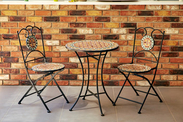 table and chairs against a backdrop of brick wall