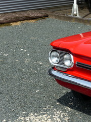 Rotes amerikanisches Heckmotor Cabriolet der Sechzigerjahre mit Doppelscheinwerfer auf grauem...