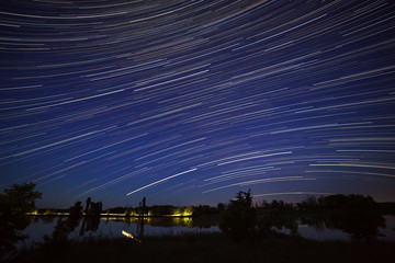 Star trails in the night sky. A view of the starry space in the background of the river.