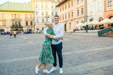 young beautiful couple of tourists stand in the square in the city of Krakow in Poland