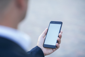 Touch screen of a mobile phone, in the hand of a businessman. Photo for Mock Up