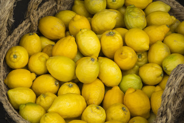 Fresh juicy lemons inside a wicker basket