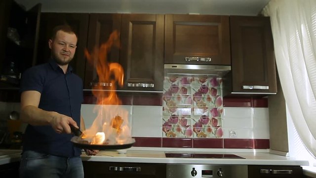 Chef cooking with flame in a frying pan
