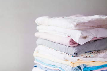 A stack of clean folded cotton clothes ready for ironing. Everyday homework concept. Soft focus.