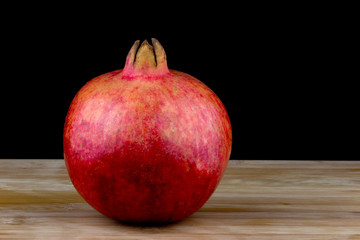 Pomegranate on a Wooden Table with Black Background