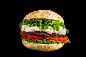 Italian version of a classic American hamburger with a meatball, fresh tomatoes and lettuce leaves and parmesan cheese sauce. European street food