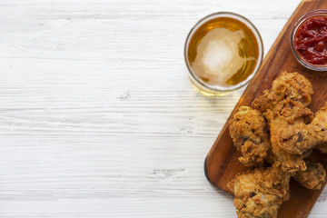 Fried chicken drumsticks with sauce and beer, from above. Selective focus. Copy space.