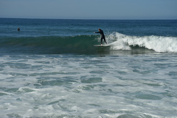 surfer riding surfboard on wave in Pacific Ocean off the coast of Baja California Sur, Mexico
