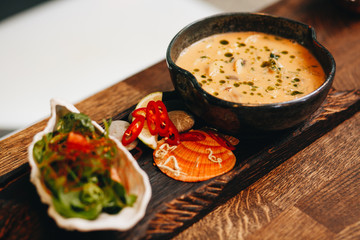 freshly cooked creamy mushroom soup in a dark clay dish.
